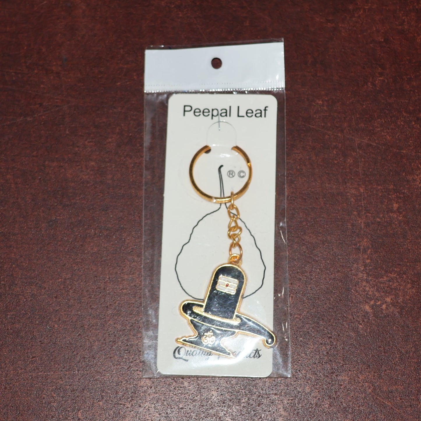 Packaging detail of golden Shivling keychain