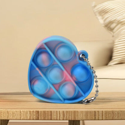 Several mini fidget keychains in various shapes and colors, demonstrating their compact size and portability.