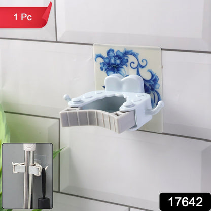 Self-adhesive mop and broom holder clip on smooth surface for cleaning tool organization